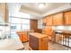 Charming kitchen featuring custom wood cabinets and a bright window over the sink at 10991 E Vassar Dr, Aurora, CO 80014
