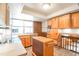 Kitchen with light wood cabinets, tiled backsplash, an island, and ample natural light at 10991 E Vassar Dr, Aurora, CO 80014