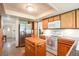 Well-lit kitchen with wood cabinets, stainless steel appliances, and a center island for prep space at 10991 E Vassar Dr, Aurora, CO 80014