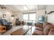 Bright living room with beamed ceiling, hardwood floors, comfortable seating, and natural light at 10991 E Vassar Dr, Aurora, CO 80014