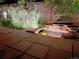 Backyard patio with a soothing, illuminated stone water feature and landscaping at 10991 E Vassar Dr, Aurora, CO 80014
