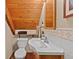 Compact bathroom features sink and toilet with wood wall detail at 563 Brook Dr, Idaho Springs, CO 80452