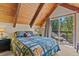 Bedroom boasts wood ceilings, forest views, and access to deck at 563 Brook Dr, Idaho Springs, CO 80452