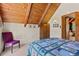 Charming bedroom with wood ceiling, built in storage, and a colorful quilt at 563 Brook Dr, Idaho Springs, CO 80452
