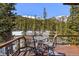 Scenic deck area with outdoor seating overlooking a forest and mountains at 563 Brook Dr, Idaho Springs, CO 80452