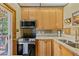 Kitchen features wood cabinets, stainless steel appliances, and access to deck at 563 Brook Dr, Idaho Springs, CO 80452