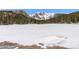 Breathtaking view of a frozen lake surrounded by snow-capped mountains and evergreen trees at 563 Brook Dr, Idaho Springs, CO 80452