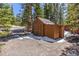 Exterior view of a wooden shed with a woodpile and double doors at 563 Brook Dr, Idaho Springs, CO 80452