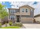 Two-story house with gray and beige siding, a two-car garage, and landscaping at 4245 S Nepal Cir, Aurora, CO 80013