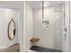 Modern bathroom featuring a shower with granite-style walls, a wooden bench, and a unique oval mirror at 1438 Little Raven St # 407, Denver, CO 80202
