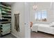 Bedroom connected to a walk-in closet; features a window with wooden shutters and a chandelier light fixture at 1438 Little Raven St # 407, Denver, CO 80202