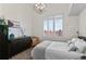 Bright bedroom featuring a large window, shutter blinds, black dresser, and a cushioned chair at 1438 Little Raven St # 407, Denver, CO 80202