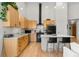 Bright kitchen featuring wooden cabinets, granite counters, black appliances, hardwood floor and a breakfast bar with stools at 1438 Little Raven St # 407, Denver, CO 80202
