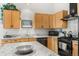 Bright kitchen featuring wooden cabinets, granite counters and backsplash and black appliances, including a gas range at 1438 Little Raven St # 407, Denver, CO 80202