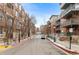 Street view of apartment buildings on either side of a paved road at 1438 Little Raven St # 407, Denver, CO 80202