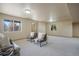 Bright finished basement space with comfortable seating and natural light from two windows at 15947 Bridle Ridge Dr, Monument, CO 80132