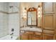 Bathroom featuring tiled shower and bathtub with wood cabinets and vanity lighting at 15947 Bridle Ridge Dr, Monument, CO 80132