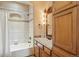 Bathroom featuring tiled shower and bathtub with wood cabinets and vanity lighting at 15947 Bridle Ridge Dr, Monument, CO 80132