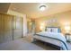 Carpeted bedroom featuring a large closet, ensuite bath and a window with decorative trim at 15947 Bridle Ridge Dr, Monument, CO 80132