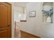 Well-lit hallway with hardwood floors, decorative niche, and view of the staircase at 15947 Bridle Ridge Dr, Monument, CO 80132