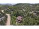 An aerial shot displays a home nestled in a dense forest, showcasing the property's serene and secluded setting at 5 Ronnie Rd, Golden, CO 80403