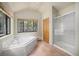 Bright bathroom showcasing a soaking tub, shower, and large window with wooded views at 5 Ronnie Rd, Golden, CO 80403