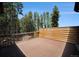 Exterior view of deck with a wooden plank accent wall surrounded by evergreen trees and blue sky at 5 Ronnie Rd, Golden, CO 80403