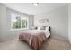 Neutral bedroom with a queen sized bed, plush bedding, a large window, and new carpeting at 10010 E Gunnison Pl # 707, Aurora, CO 80247