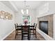 Bright dining room featuring a fireplace and a modern light fixture over a dark wood table at 10010 E Gunnison Pl # 707, Aurora, CO 80247