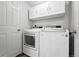 Bright laundry room with white washer and dryer, white cabinets, and a white door at 10010 E Gunnison Pl # 707, Aurora, CO 80247