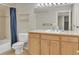 Bathroom with a large mirror, vanity with storage, and tub shower with blue curtains at 10877 W 55Th Ln, Arvada, CO 80002