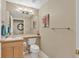 Powder room featuring a single vanity sink, mirror, and toilet at 10877 W 55Th Ln, Arvada, CO 80002