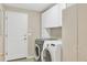 Laundry room with white cabinets and modern washer and dryer units at 10877 W 55Th Ln, Arvada, CO 80002