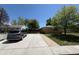 Exterior view of home, driveway, and side yard with lush greenery and a blue sky at 8307 E 14Th Ave, Denver, CO 80220