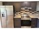 Modern kitchen with stainless steel appliances, granite countertops, and stylish backsplash at 8307 E 14Th Ave, Denver, CO 80220