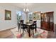 Cozy dining area with a modern chandelier, wood table, and large windows for ample natural light at 14791 E Poundstone Dr, Aurora, CO 80015