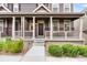 Charming two-story home featuring a covered front porch with stately columns and manicured landscaping at 14791 E Poundstone Dr, Aurora, CO 80015