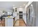 Modern kitchen with stainless steel appliances, white cabinetry, and an island with bar stool seating at 14791 E Poundstone Dr, Aurora, CO 80015