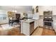 Bright, open kitchen with stainless steel appliances and white cabinets, adjacent to the dining area at 14791 E Poundstone Dr, Aurora, CO 80015