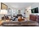 Spacious living room with leather sofas, wood floors, and natural light creating a cozy ambiance at 14791 E Poundstone Dr, Aurora, CO 80015