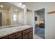 This bathroom features double sinks, dark cabinetry, marble counters, and a shower at 819 Meadow Ln, Palmer Lake, CO 80133