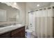 Bathroom with a sink, dark wood cabinet, a toilet and a shower/bath with a white shower curtain at 819 Meadow Ln, Palmer Lake, CO 80133