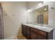 Bathroom boasts double sinks, dark cabinetry, marble countertops, and framed mirrors at 819 Meadow Ln, Palmer Lake, CO 80133