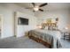 Bedroom with gray carpet, ceiling fan, rustic decor, log headboard, and mounted television at 819 Meadow Ln, Palmer Lake, CO 80133