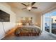 Bedroom features gray carpet, ceiling fan, rustic décor, king bed, and access to a private patio at 819 Meadow Ln, Palmer Lake, CO 80133