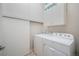 Modern laundry room with white washer and dryer, storage cabinets, and tile floors at 819 Meadow Ln, Palmer Lake, CO 80133