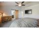 The main bedroom features a decorative dresser, barn door to bathroom, ceiling fan, and mounted TV at 819 Meadow Ln, Palmer Lake, CO 80133