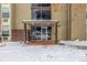 Apartment complex entrance showcasing glass doors, chairs, and snow-covered brick patio at 2281 S Vaughn Way # 316A, Aurora, CO 80014