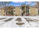 Tan apartment building exterior with balconies, stairs, and snow-covered parking at 2281 S Vaughn Way # 316A, Aurora, CO 80014