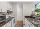 Galley kitchen features white cabinetry, granite countertops, and modern appliances at 2281 S Vaughn Way # 316A, Aurora, CO 80014